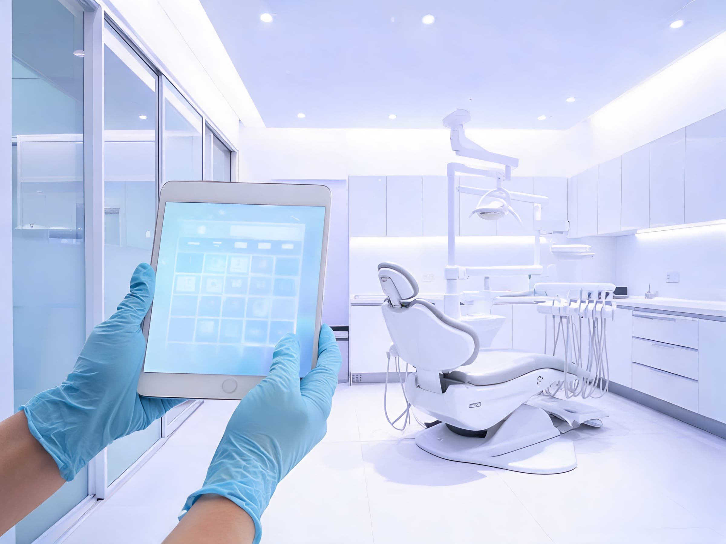 Gloved hands holding a tablet in a bright Dubai dental clinic treatment room